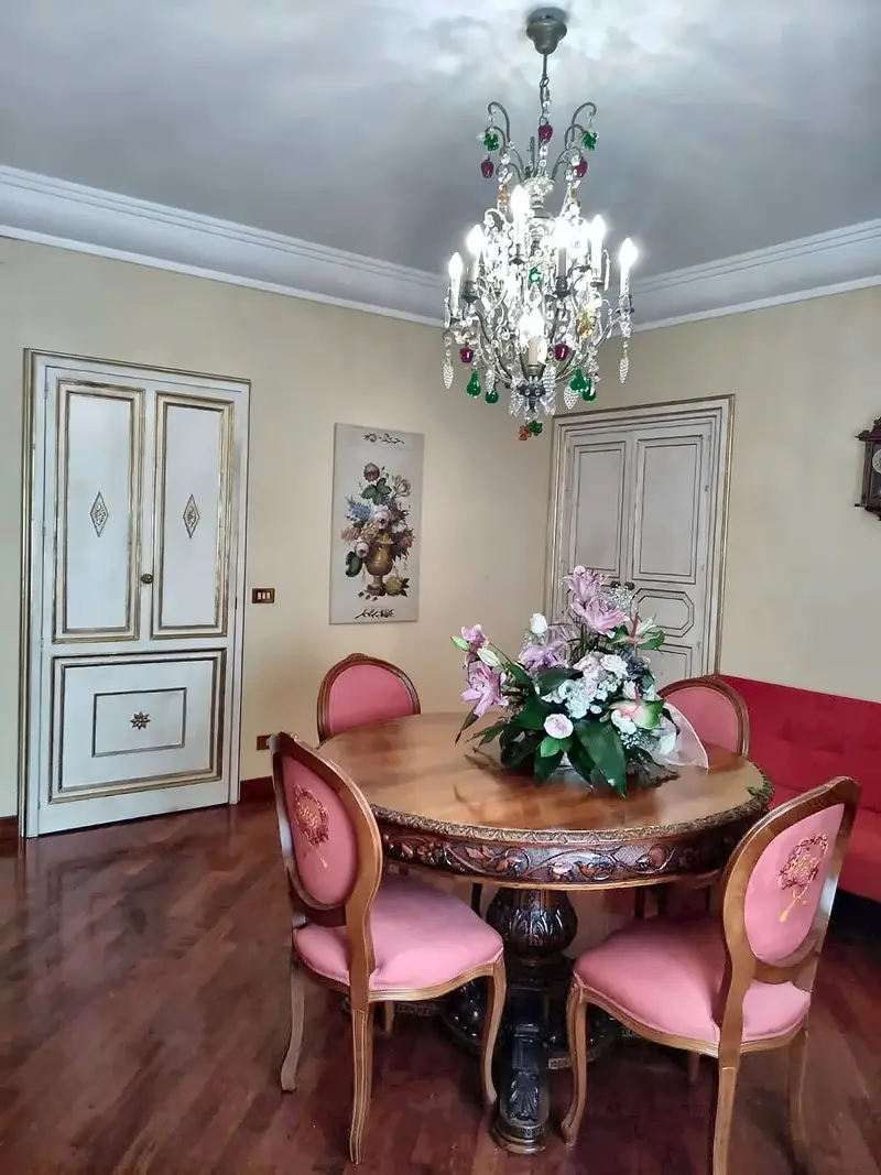 Sala da pranzo con sedie imbottite e fiori (ingrandisci)